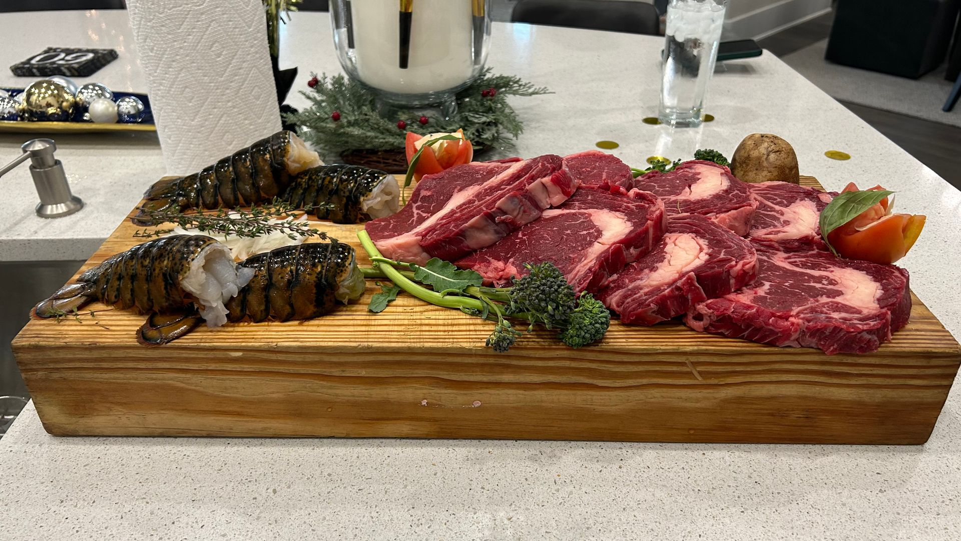 A wooden cutting board filled with meat and vegetables on a counter.