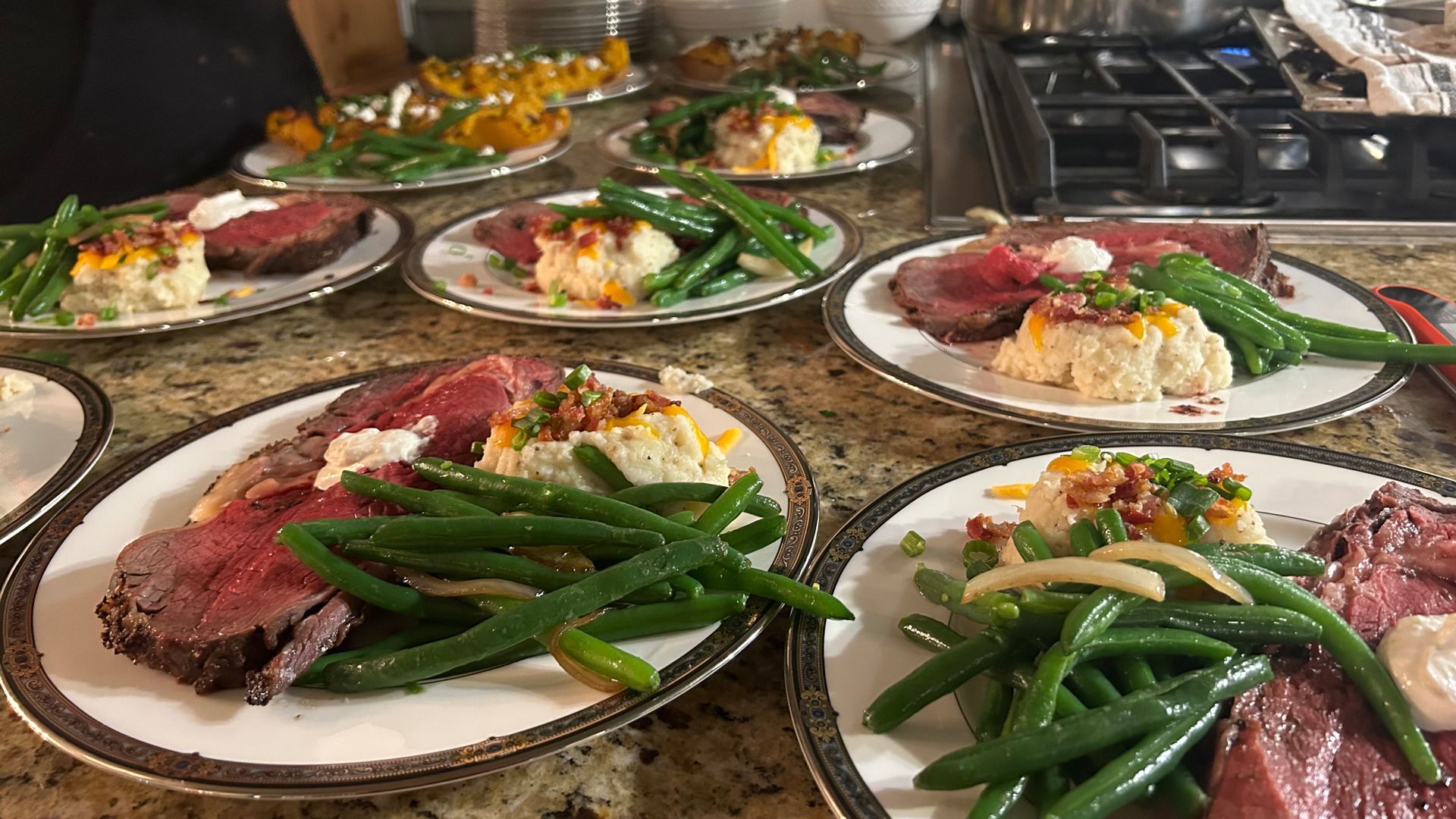 A table topped with plates of food and green beans.