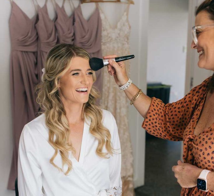 A woman is applying makeup to another woman 's face.