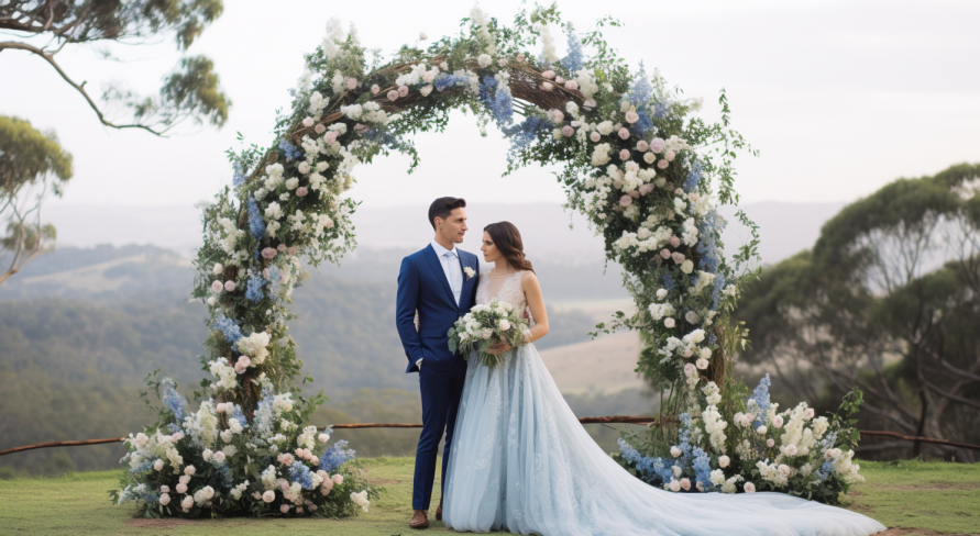 A bride and groom are standing under a floral arch at their wedding.