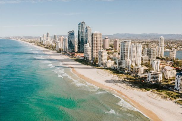 An aerial view of a beach with a city in the background.