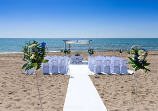 A wedding ceremony is taking place on the beach.