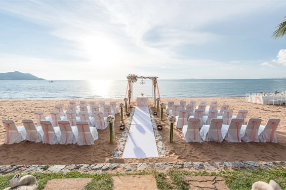 A wedding ceremony is taking place on the beach.