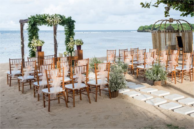 A wedding ceremony is taking place on the beach.