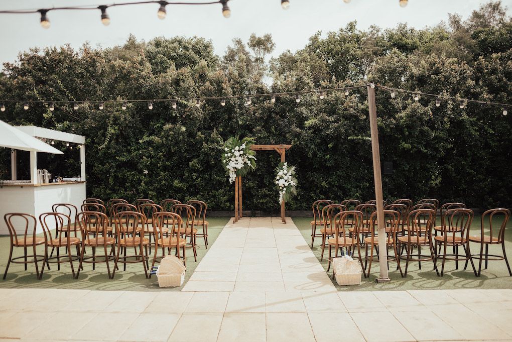 A row of chairs are lined up in front of a wooden archway.