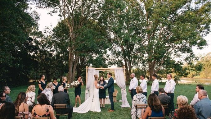 A bride and groom are getting married in front of their wedding guests.