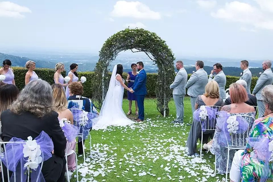 A bride and groom are getting married in front of a crowd of people.