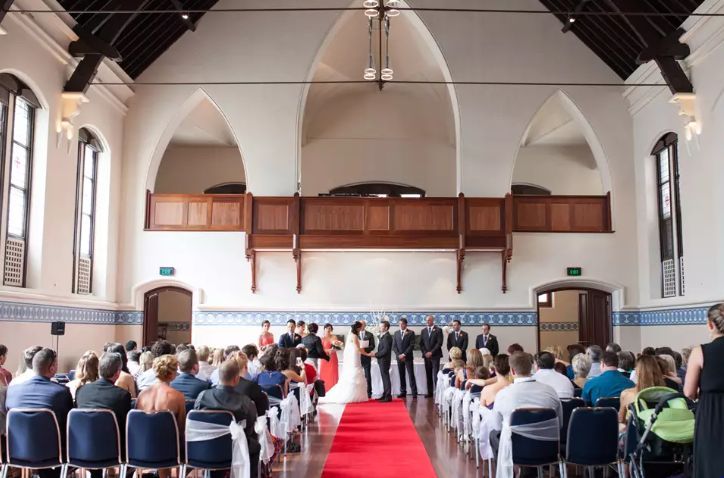 A wedding ceremony in a church with a red carpet