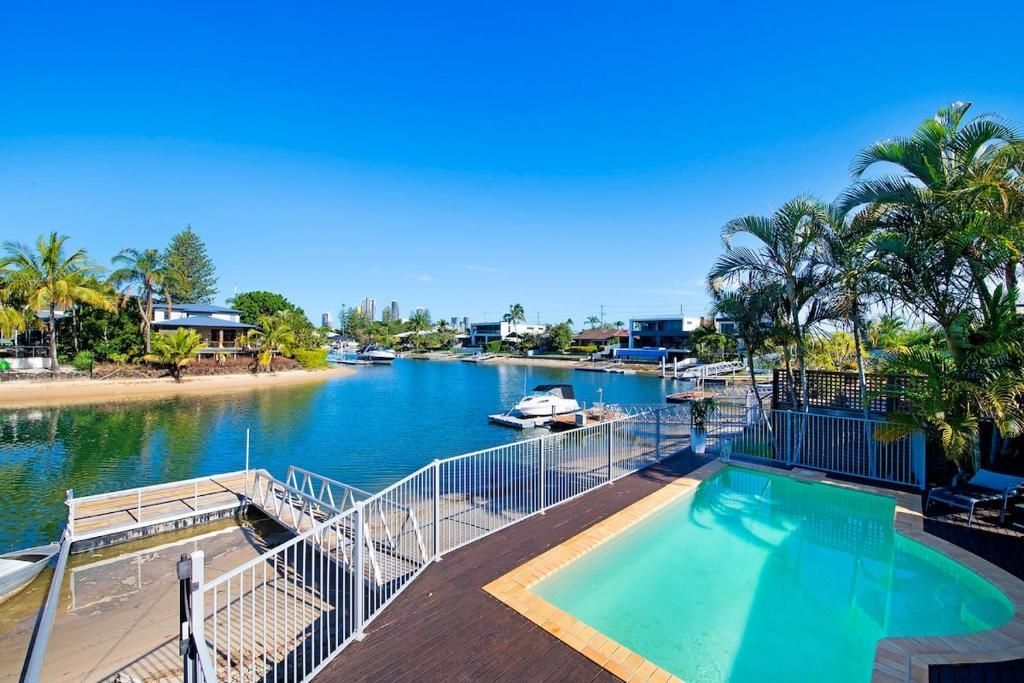 A large swimming pool surrounded by a fence next to a body of water.