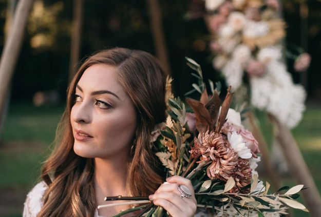 A woman is holding a bouquet of flowers in her hands.