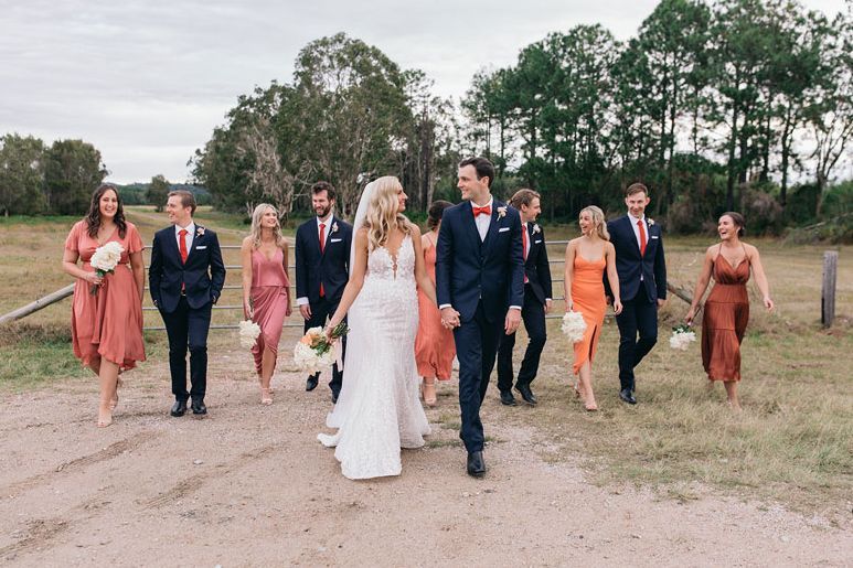 A bride and groom are walking with their wedding party.