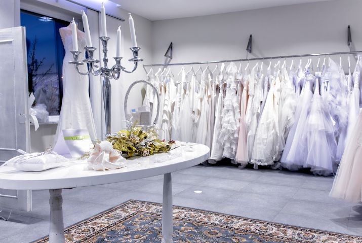 A room filled with lots of wedding dresses and a table.