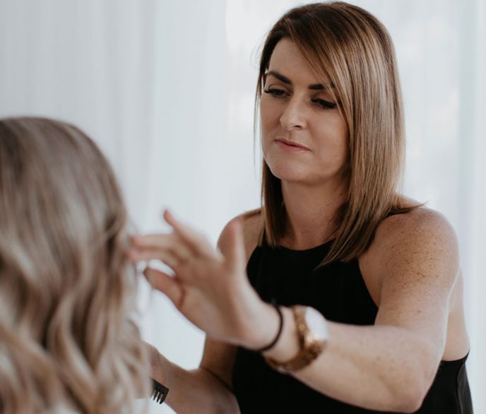 A woman is applying makeup to another woman 's face.