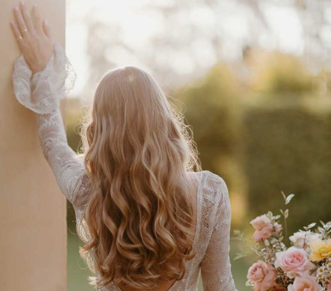 A woman in a white dress is holding a bouquet of flowers.