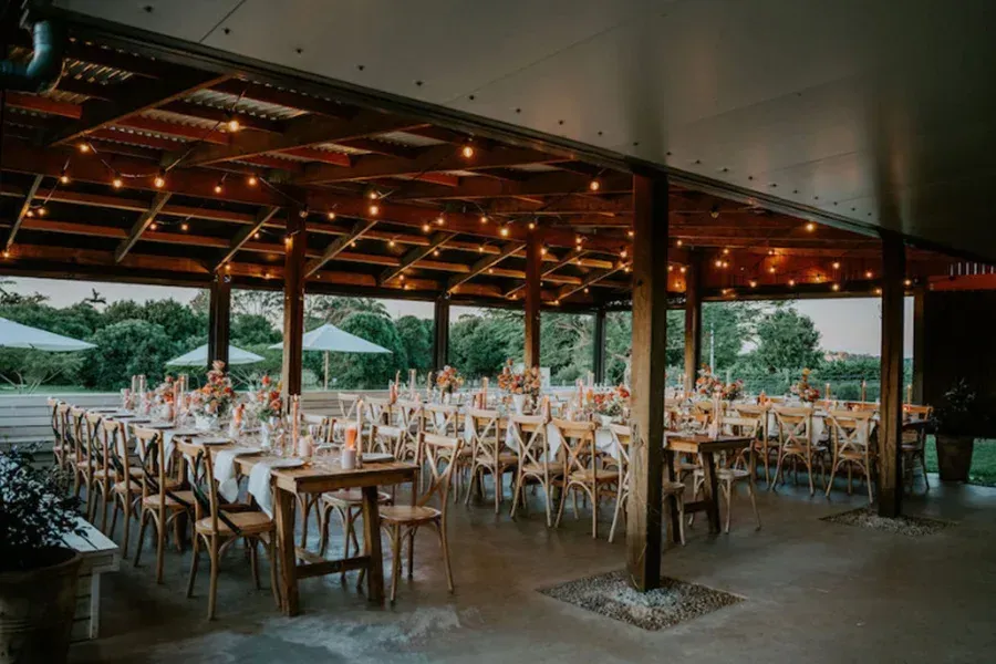 A large room with tables and chairs set up for a wedding reception.
