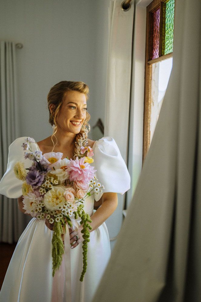 The bride is wearing a white dress and holding a bouquet of flowers.
