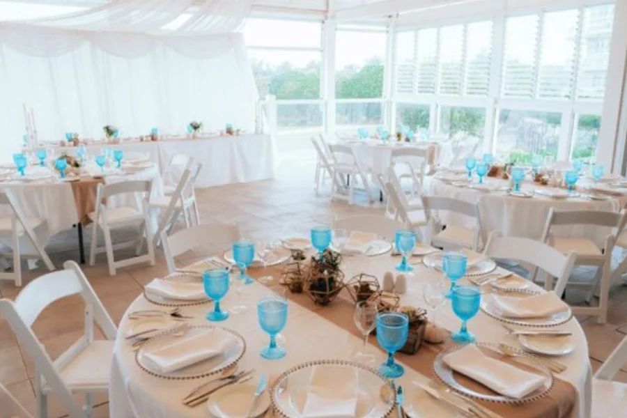 A room filled with tables and chairs set up for a wedding reception.