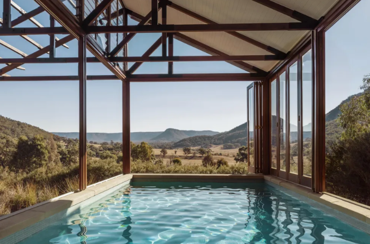 A large indoor swimming pool with a view of the mountains