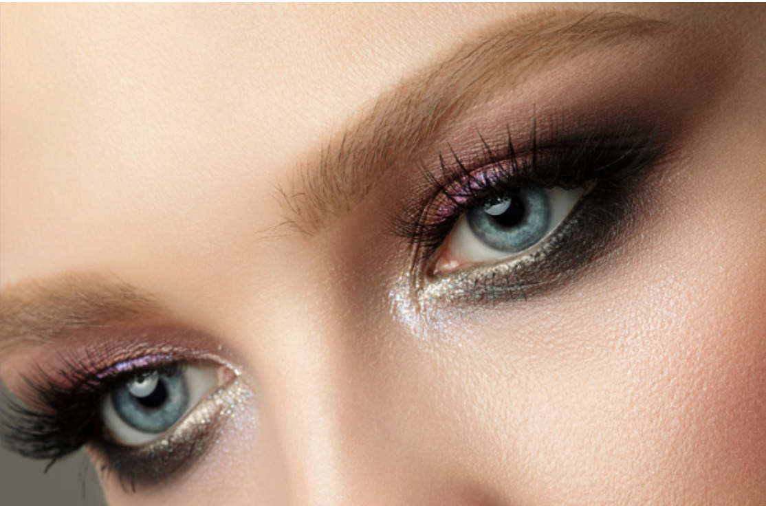 A close up of a woman 's eyes with smokey eye makeup.