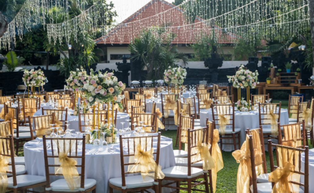 A bunch of tables and chairs are set up for a wedding reception.