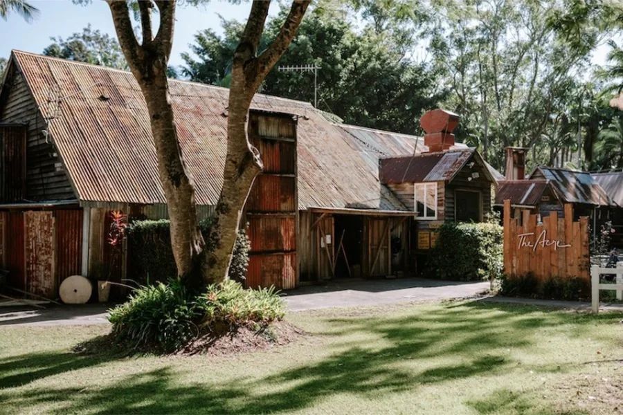 A large wooden house with a tree in front of it.