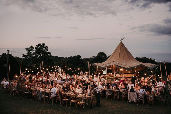 A large room with tables and chairs set up for a wedding reception.