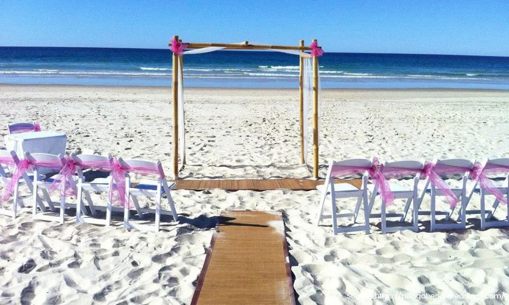 A beach with chairs and a wooden archway