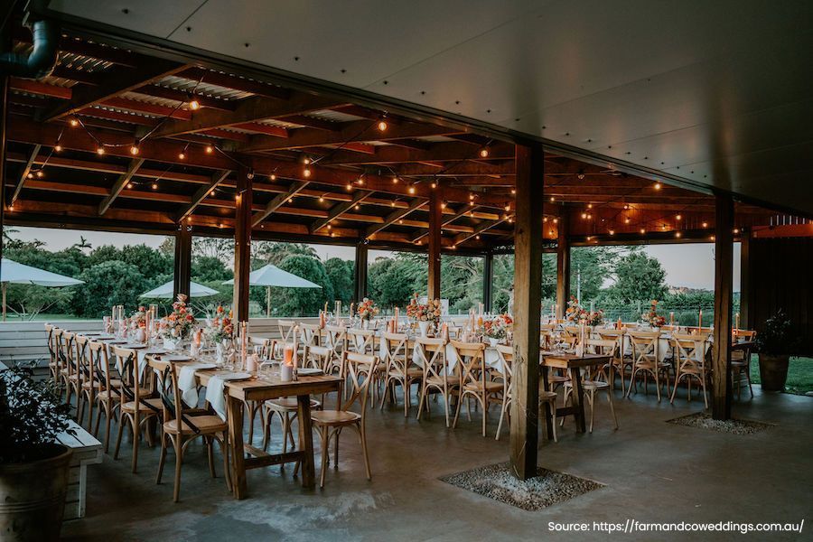 A large room with tables and chairs set up for a wedding reception.