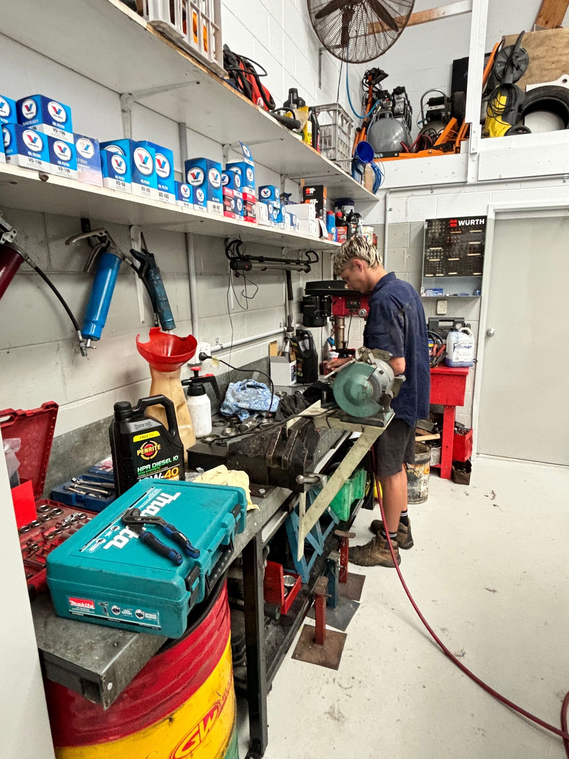 A man is working on a machine in a garage. — Sure Stop Automotive Centre In Nerang, QLD