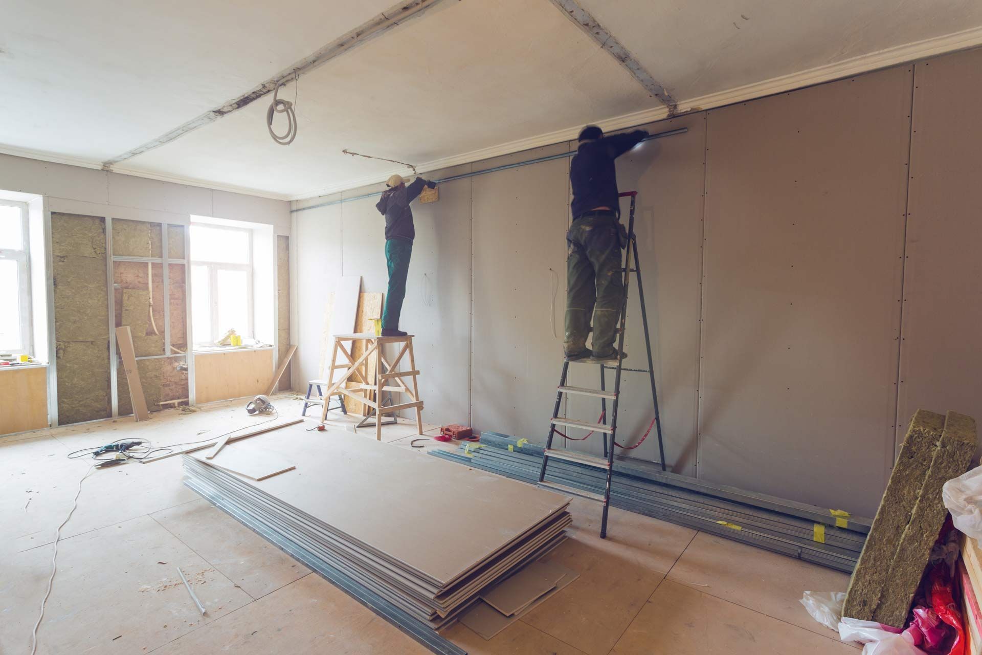 general contractor in richmond va: Two men are working on a wall in a room