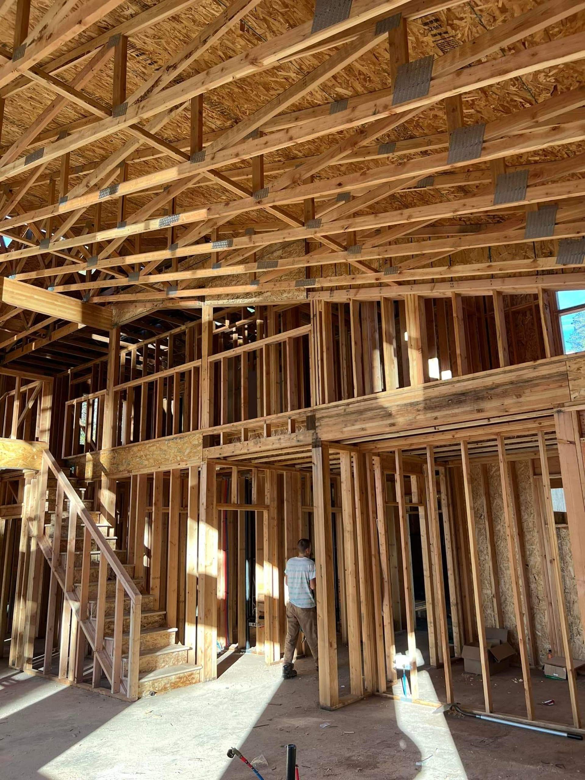 general contractor in richmond va: A man is standing in the middle of a house under construction