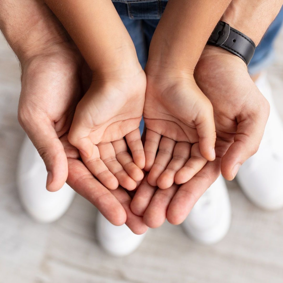A man and a child are holding their hands together