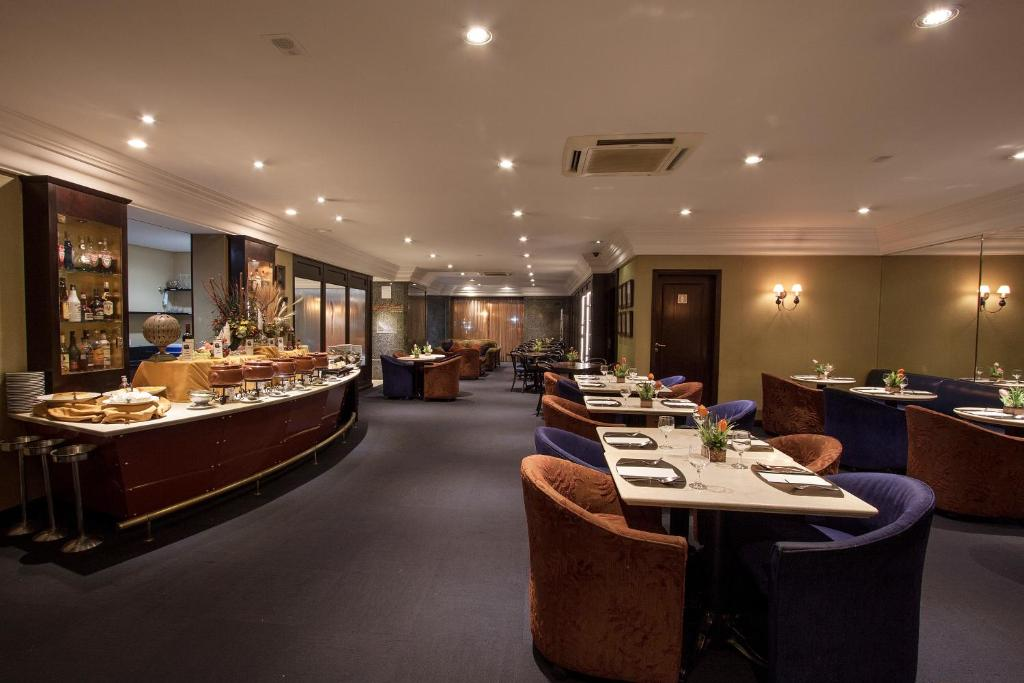 Sala de jantar elegante do restaurante com mesas postas, iluminação aconchegante e balcões de buffet.
