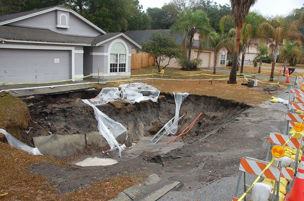 A large hole in the ground in front of a house