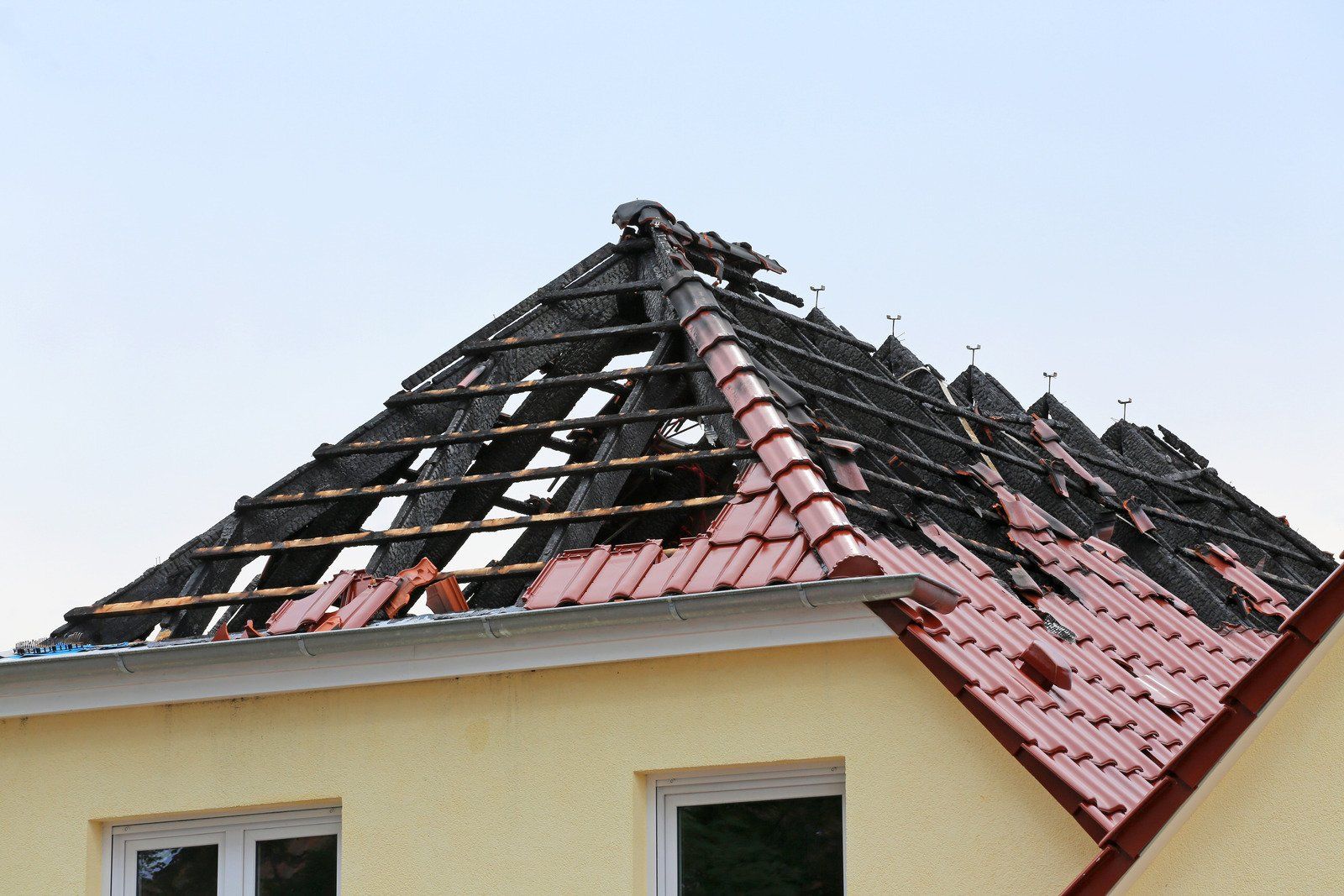 A house with a roof that has been damaged by fire