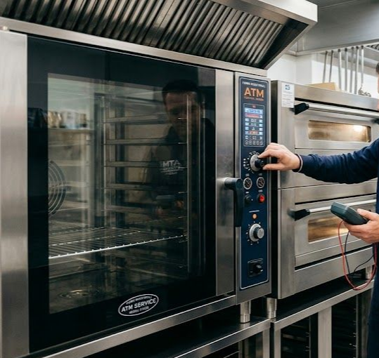 Persona che aziona un forno commerciale in acciaio inox con pannello di controllo digitale in una cucina