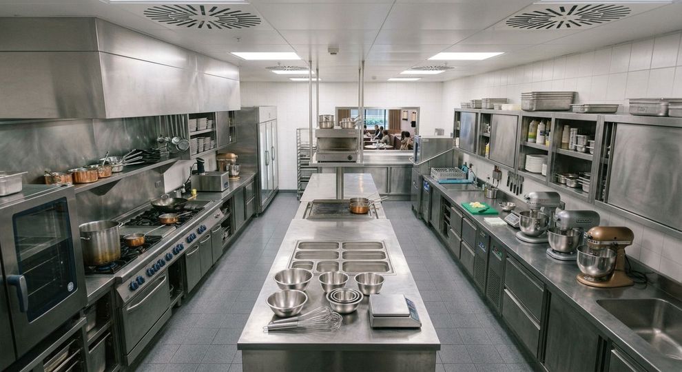 Un tecnico utilizza un trapano elettrico giallo per installare una lavastoviglie in un mobile da cucina.