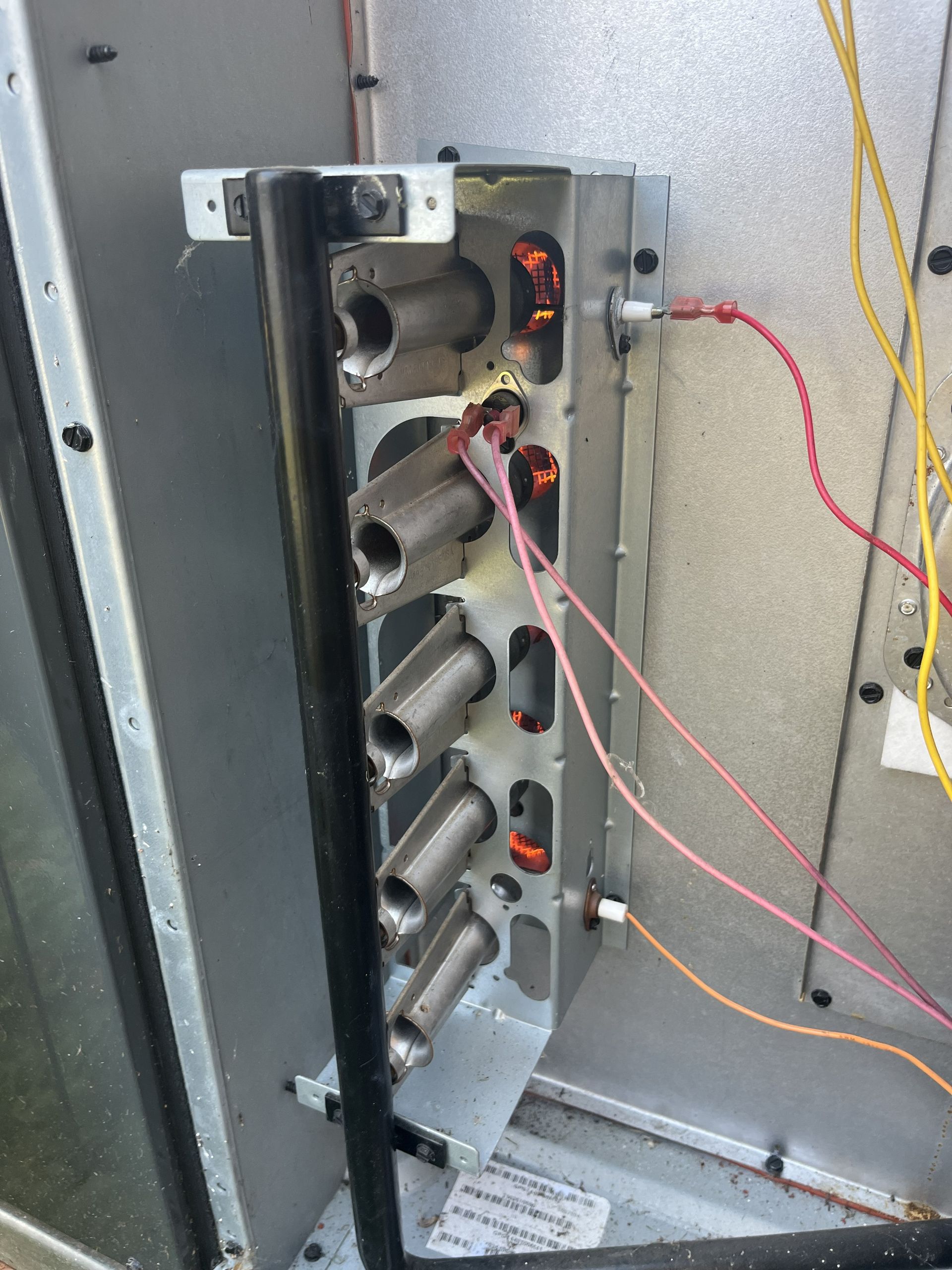 Damaged electrical panel with exposed wiring and metal housings inside a wall cavity