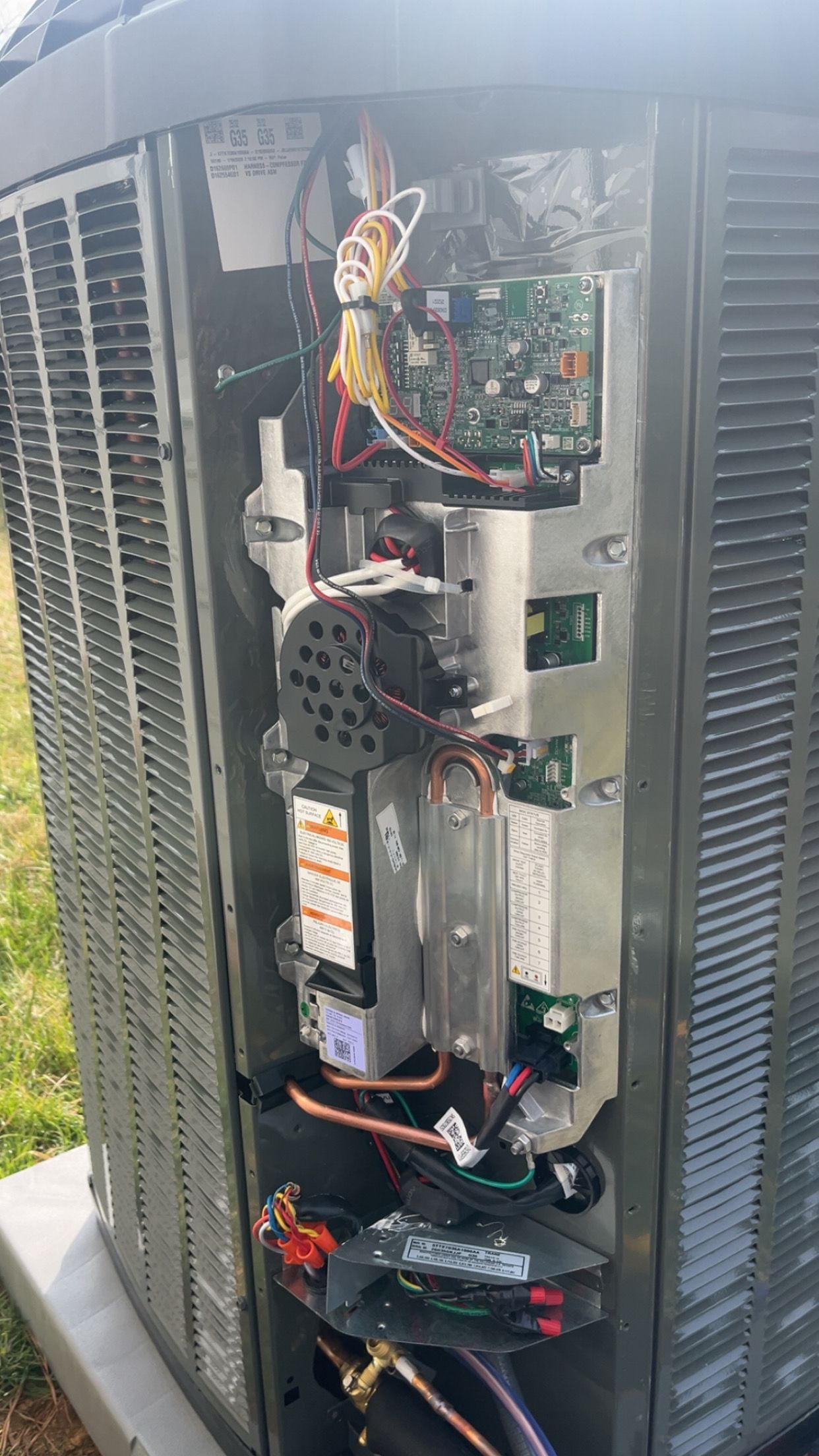 Open server cabinet with exposed wiring, circuit boards, and metal components outdoors.