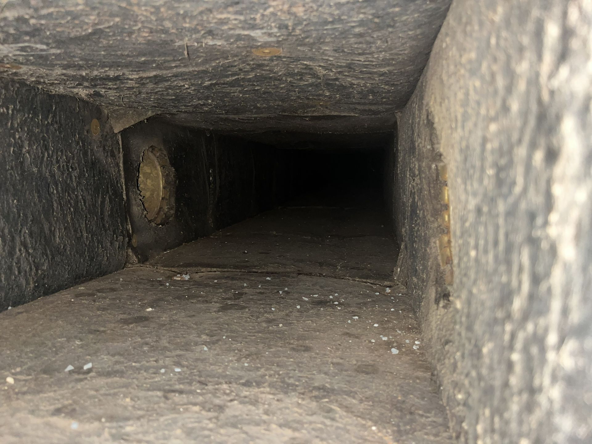 Dark stone tunnel interior with a narrow rectangular opening fading into darkness