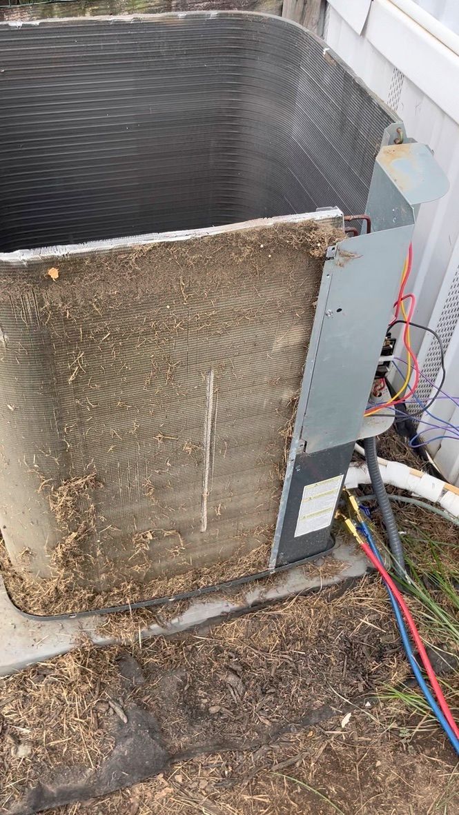Outdoor HVAC unit with a damaged, rusted coil and exposed wiring near the side panel