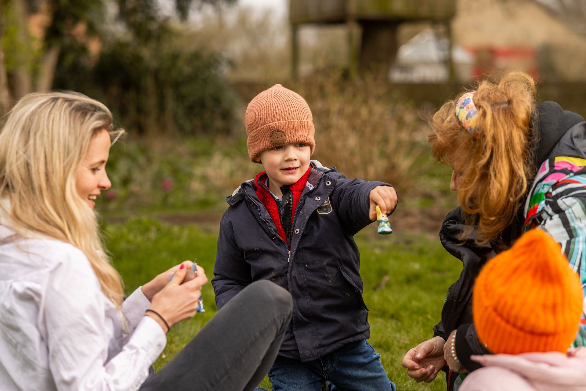 A group of people are playing with a child in a park.