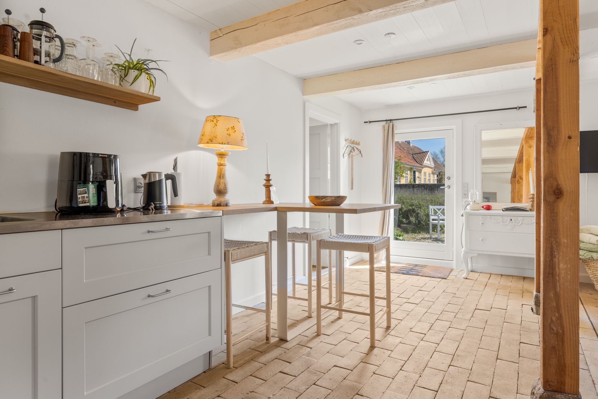 A kitchen with white cabinets and a wooden table and chairs.