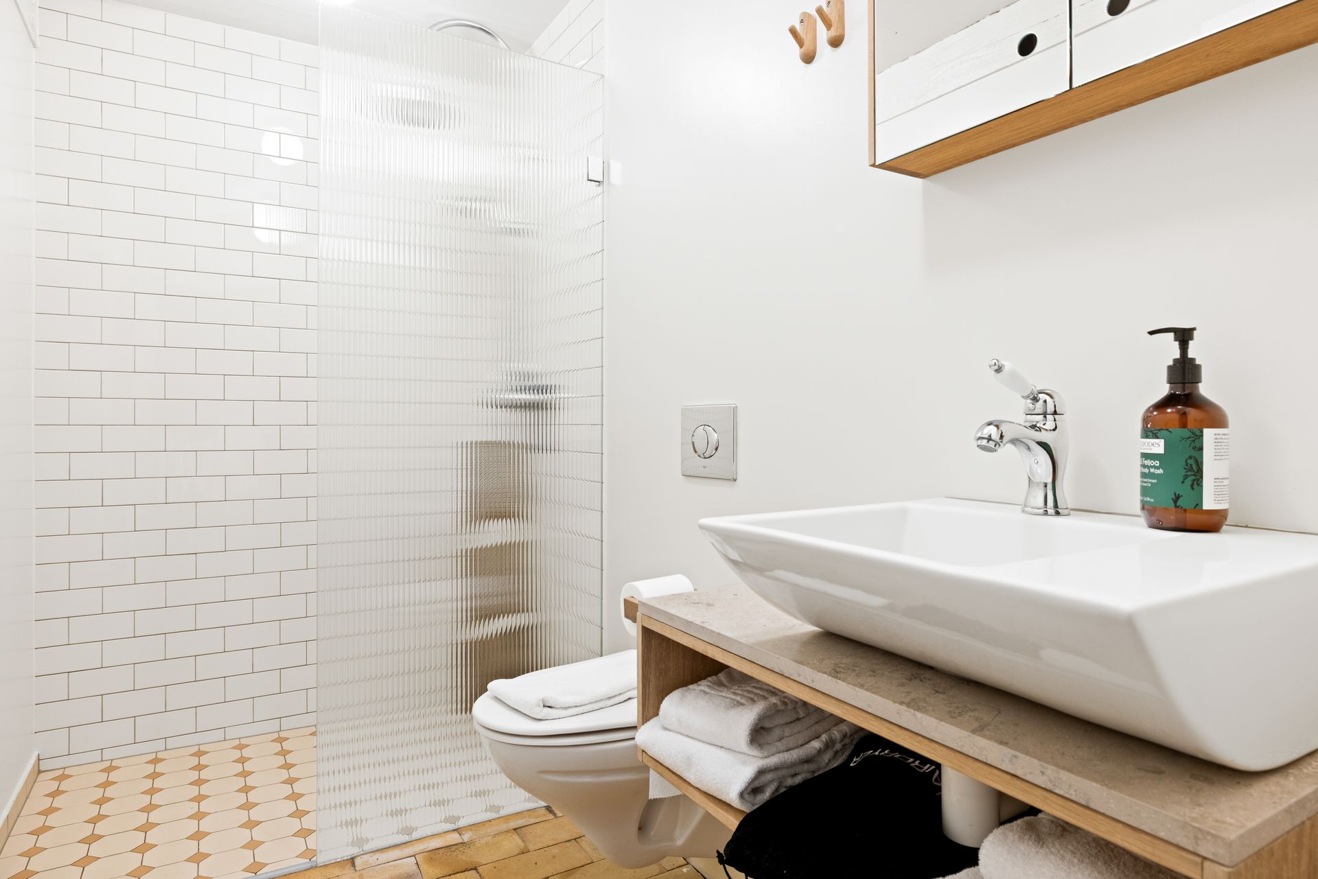 A bathroom with a sink , toilet and shower.