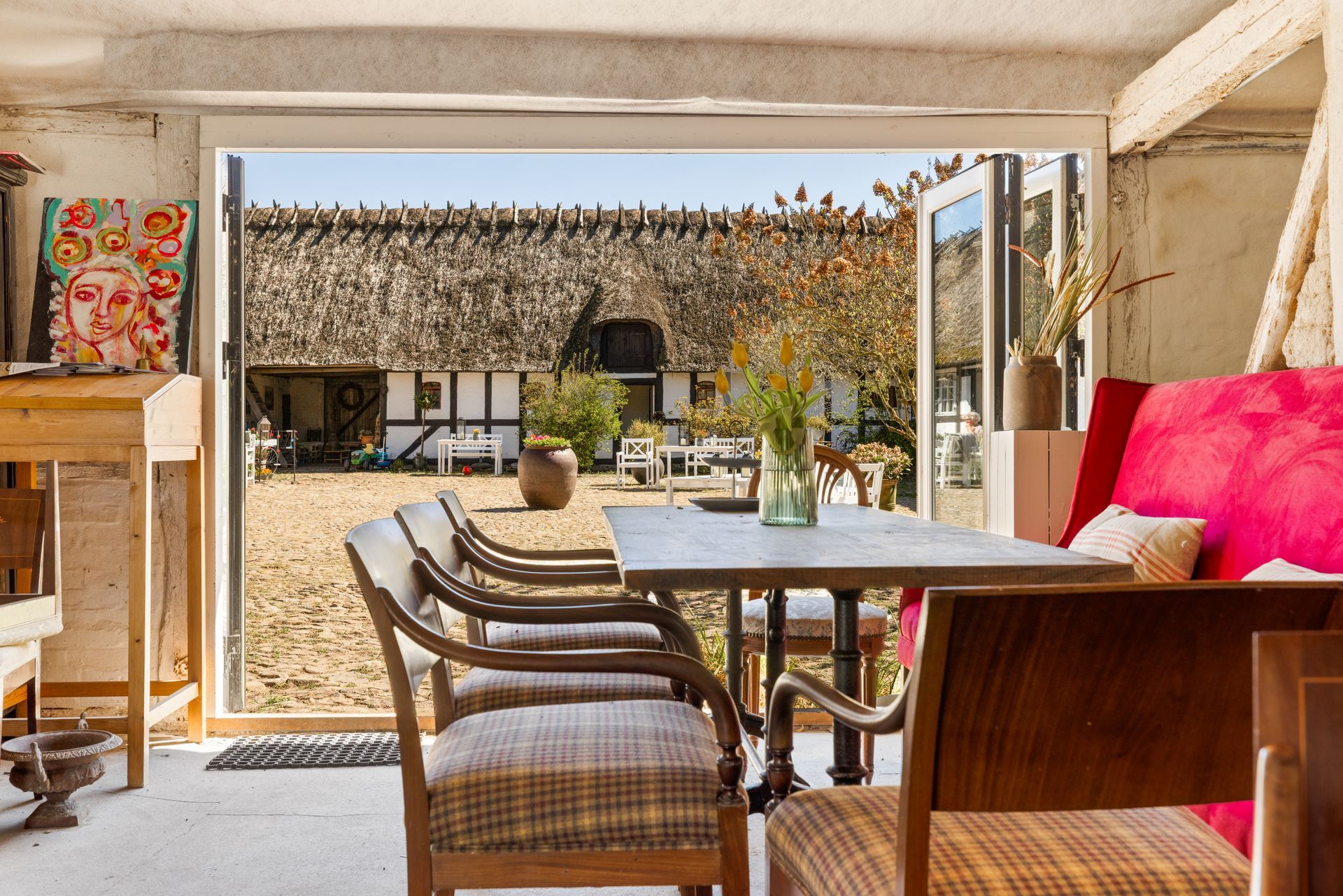 A living room with a table and chairs and a view of a barn.