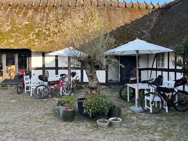 A thatched roofed building with bicycles parked in front of it.