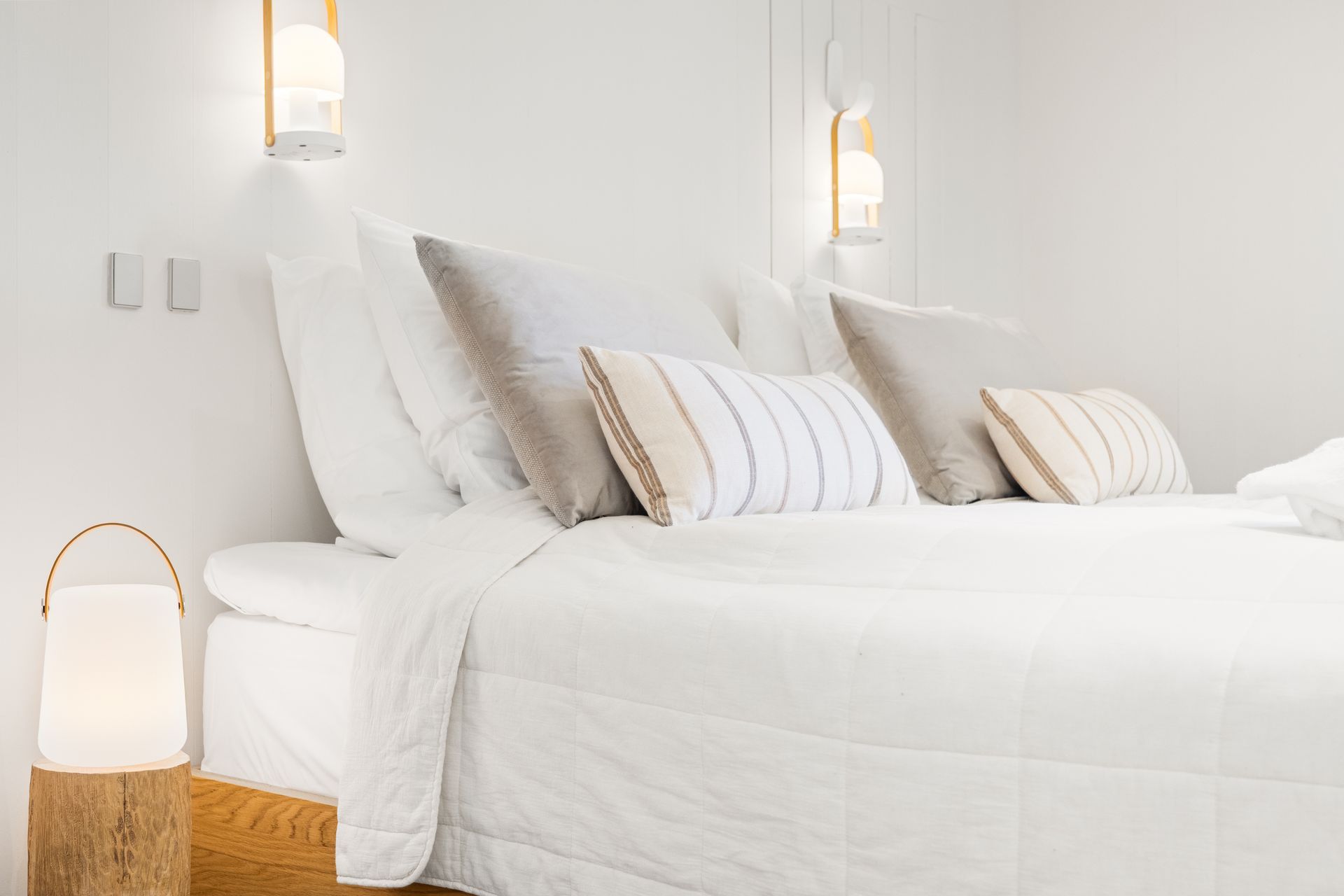 A bed with white sheets and pillows in a bedroom.