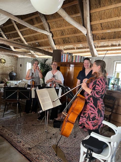 A group of people are playing instruments in a room.