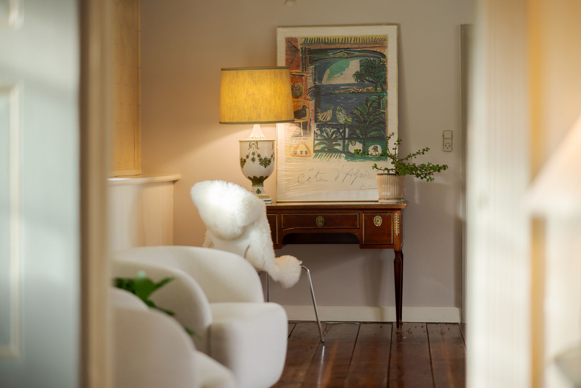 A room with a table and chairs and a painting on the wall
