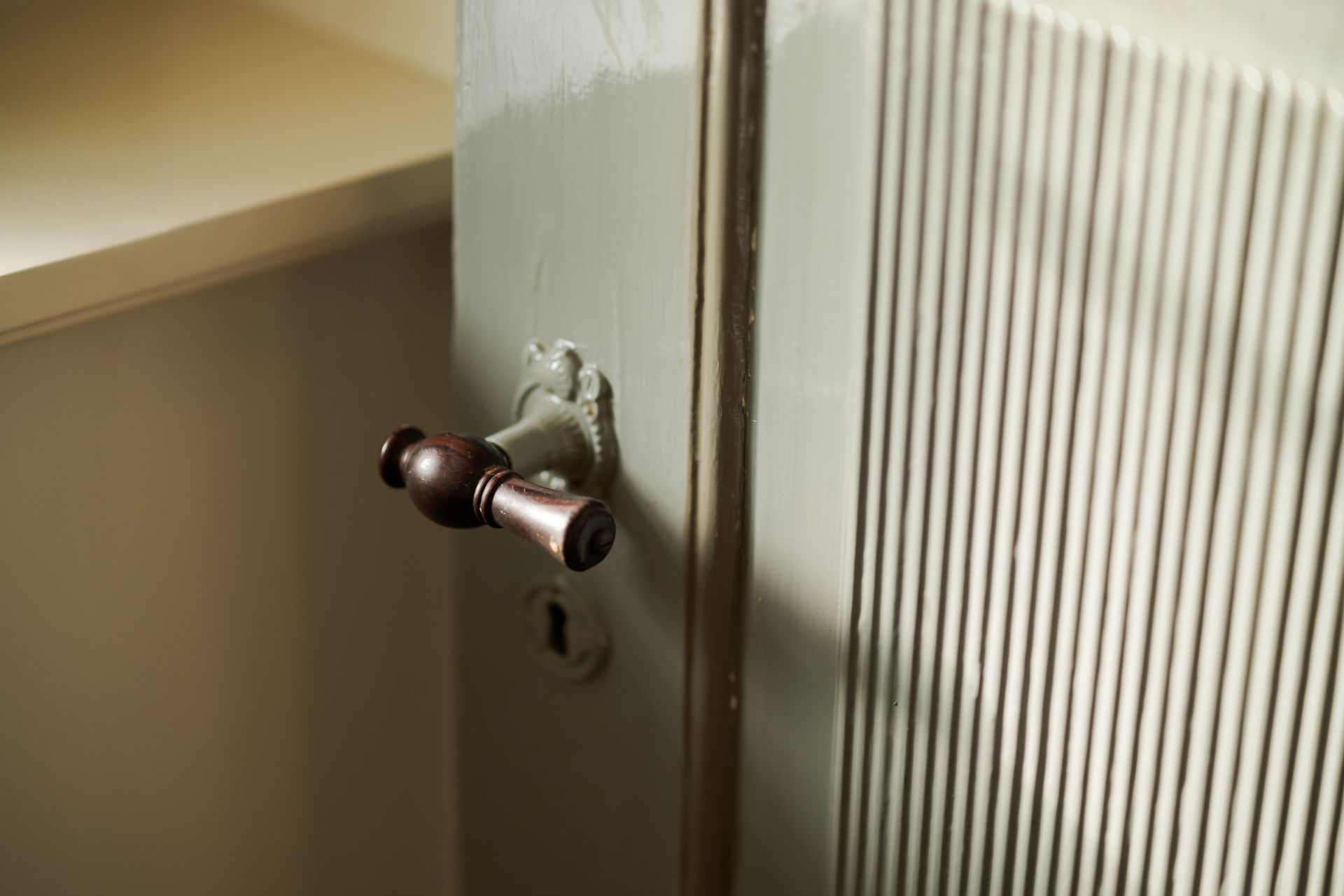 A close up of a door with a wooden handle and a key.